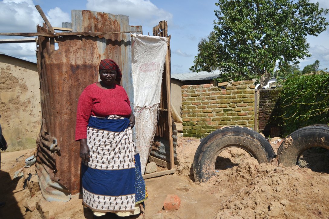 Shakira mother in front of temp latrine